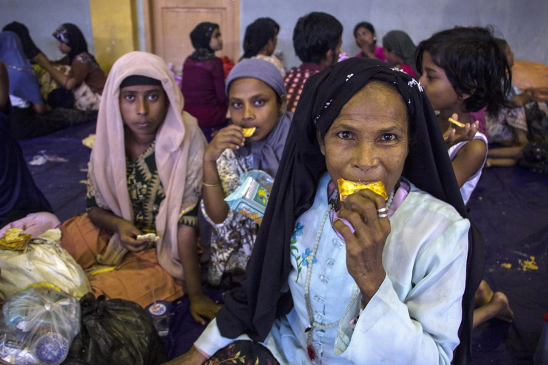 Rohingya Muslim migrants originating from Myanmar eat breakfast as they are sheltered in the sport stadium of Lhok Sukon, North Aceh, Sumatra, Indonesia, 11 May 2015. Indonesia on 10 May 2015 rescued more than 500 Myanmar Rohingya found drifting in a boat off the North Aceh coast. Many Rohingya Muslims, a stateless minority in predominately Buddhist Myanmar, often escape by travelling to Malaysia and Indonesia through Thailand by boats and cars that are run by smugglers, who hold them in captivity until ransom is paid by their family back home. EPA/ZIKRI MAULANA