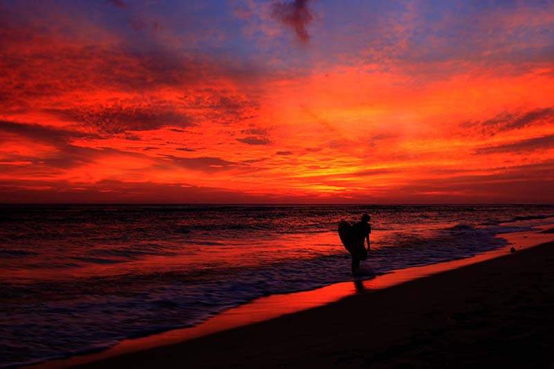 Surfer kembali ke pantai saat suasana sunset di pantai Kuala Cut Lampuuk, Aceh Besar (Foto M Iqbal/SeputarAceh.com)