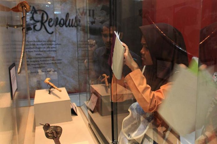 Siswa menulis informasi dari benda sejarah acara 100 tahun museum Aceh (Foto M Iqbal/SeputarAceh.com)