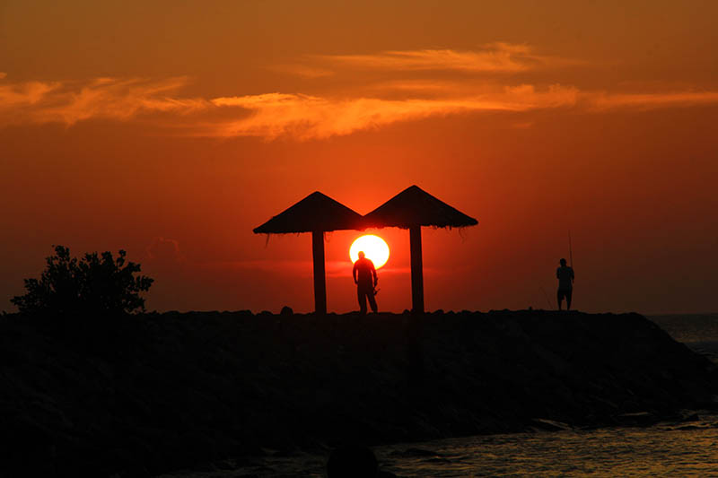 Pemancing berjalan melewati matahari, menjelang sunset di pantai Kuala Cut Lampuuk, Aceh Besar (Foto M Iqbal/SeputarAceh.com)