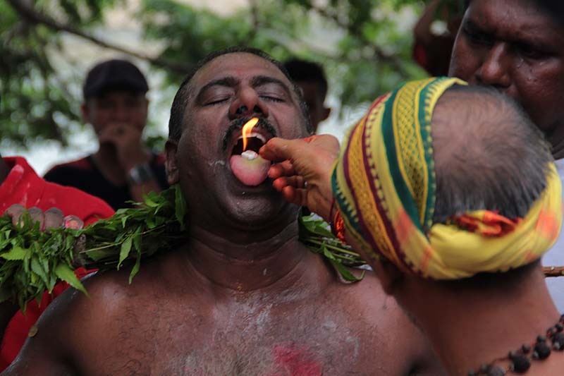 Gurukel Kuil Palani Andawer memasukkan unsur api kedalam mulut Pandita sebagai salah satu syarat medium masuknya kekuatan Dewa Murugan (Foto M Iqbal/SeputarAceh.com)