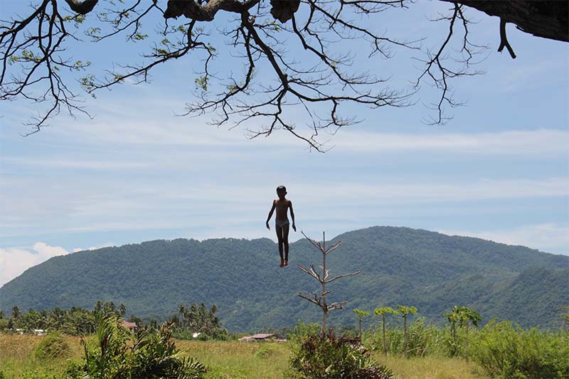 Seorang anak loncat dari dahan pohon terjun ke sungai di gampong Nusa (Foto M Iqbal/SeputarAceh.com)